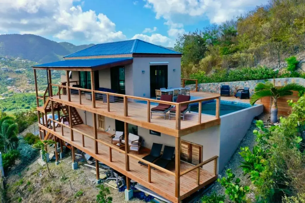 Panoramic view of the entire house, showcasing the top, mid, and terrace levels, with a backdrop of majestic mountains.